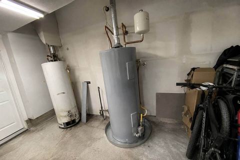 Water heater in a garage, standing in a drip pan