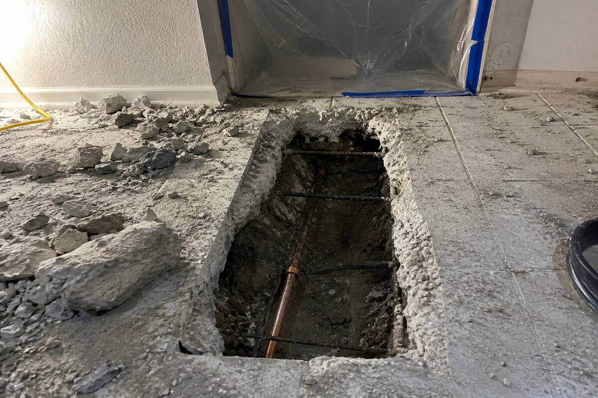 Concrete floor cut open to reach a leaking pipe under a slab